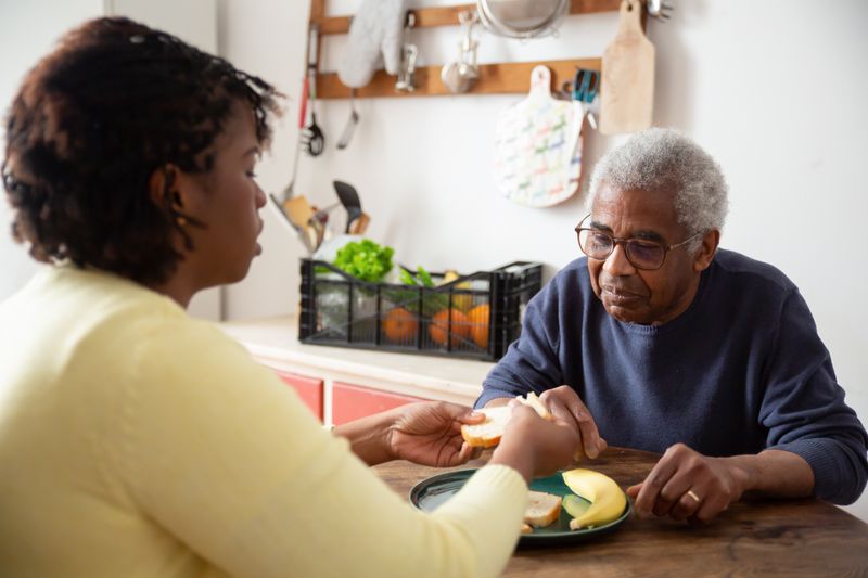 Caregiver sharing a meal with senior resident